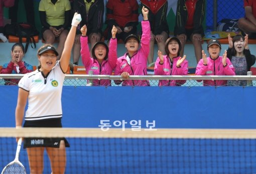 농협은행 김애경(왼쪽 흰옷)이 9일 제90회 동아일보기 정구대회 여자 일반부 단체전에서 안성시청 김보미를 꺾고 우승을 확정짓는 
순간 왼손을 치켜들며 환호하고 있다. 농협은행 선수단도 응원석에서 함께 기뻐하고 있다. 농협은행은 3-1로 안성시청을 꺾고 대회 
4연패를 달성했다.  문경｜이훈구 동아일보 기자 ufo@donga.com