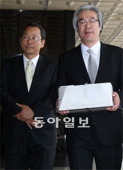 노무현재단 ‘趙 수사’ 축하떡 9일 노무현재단 관계자들이 ‘조현오 수사 축하 기념떡’을 들고 서울 서초구 서초동 서울중앙지검 청사로 들어서고 있다. 양회성 기자 yohan@donga.com