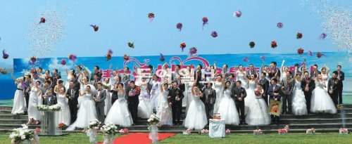 예식장은 성산일출봉 9일 오전 유네스코 세계자연유산이자 세계지질공원인 제주 성산일출봉에서 중국 헤이룽장 성 다칭 시 신혼부부 35쌍이 합동결혼식을 올린 뒤 부케를 하늘 높이 던지며 환호하고 있다. 이날 주례사는 우근민 제주지사와 지융 다칭미디어 회장이 맡았다. 서귀포=임재영 기자 jy788@donga.com