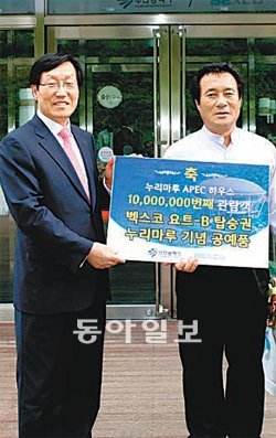 부산 해운대 동백섬 누리마루 APEC하우스 1000만 번째 방문객인 오광록 씨(오른쪽)가 김철도 벡스코 경영본부장으로부터 기념품을 받고있다. 벡스코 제공