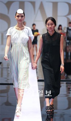 14일 싱가포르 니안시티에서 열린 아시아패션익스체인지 ‘아우디 스타크리에이션’에서
우승을 차지한 고영지 씨(오른쪽)가 자신이 만든 의상을 입은 모델과 함께 런웨이를 걷고 있다. 색동을 응용한 파스텔톤 줄무늬 원피스와 족두리를 재해석한 머리장식 등 한국적 요소를 선보여 높은 평가를 받았다. 아우디 스타크리에이션 제공