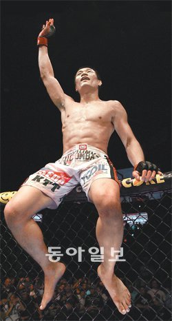 ‘코리안 좀비’ 정찬성이 16일 UFC 페더급 경기에서 더스틴 포이리에를 꺾고 옥타곤 철망 위에 걸터앉아 손을 흔들어 관중의 환호에 답하고 있다. 브라보 초크로 4라운드 1분 7초 만에 포이리에를 제압한 정찬성은 경기 후 챔피언 도전 의사를 표시했다. UFC 제공