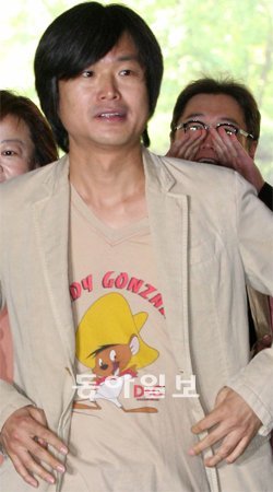 주진우 응원하는 김용민 선거법 위반 혐의를 받는 시사IN 주진우기자가 18일 오전 서울지방경찰청에 들어서고 있다. 바로 뒤에서 ‘막말 파문’의 장본인 김용민 씨가 응원구호를 외치고 있다. 양회성 기자 yohan@donga.com