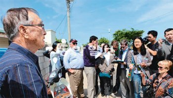 18일 연평도 포격 현장을 찾은 외신 기자들에게 주민 김유성 씨(왼쪽)가 북한의 도발
당시 상황을 설명하고 있다. 아리랑TV 제공