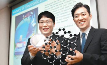 삼성전자 종합기술원의 박성준 전문연구원(오른쪽)과 정현종 전문연구원이 그래핀 구조
모형과 웨이퍼를 들고 활짝 웃고 있다. 삼성전자 제공