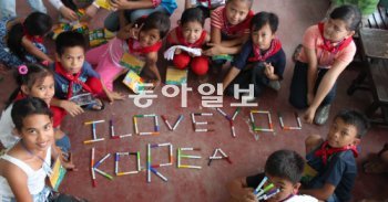 화재로 무너진 학교를 다음커뮤니케이션 지원으로 되찾은 필리핀 나보타스 시 산로케 ‘지구촌 희망학교’ 학생들이 15일 펜을 이어붙여 ‘사랑해요, 한국(I love you Korea)’이라는 글자를 만들어 보이고 있다. 나보타스=조건희 기자 becom@donga.com