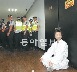 서버 관리업체 지키는 강기갑 21일 오후 11시 30분경 검찰이 통합진보당 서버를 관리하는 서울 금천구 가산동 스마일서브 사무실에 대한 압수수색을 실시하기에 앞서 강기갑 통진당 혁신비상대책위원장이 홀로 문 앞을 막고 앉아 있다. 김재명 기자 base@donga.com