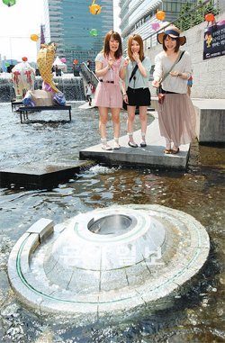 “행운을 잡으세요” 22일 일본인 관광객들이 서울 청계천 ‘행운의 동전’에 동전을 던져 넣고 있다. 2005년부터 이달 16일 현재까지 모인 동전은 8033만 원. 이훈구 기자 ufo@donga.com