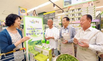윤팔한 보성유기농녹차협회장(오른쪽에서 두 번째) 등 녹차 재배농민들이 22일 서울 용산역 이마트 매장에서 고객에게 햇녹차를 권하고 있다. 이마트 제공