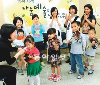 다문화가정 엄마들이 지난달 23일 바이올린을 켜는 아이들에게 격려의 박수를 보내고 있다. 뒤쪽 아이를 안고 있는 이가 사카모토 씨다. 서영수 기자 kuki@donga.com
