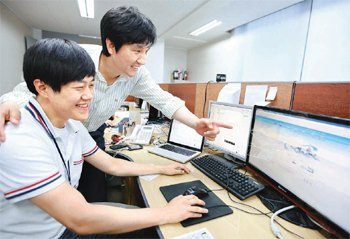 코리아로지스의 개발실에서 김영남 대표(오른쪽)가 시스템 개발자와 함께 모니터 화면을 보고 있다. 이 사무실은 아파트형 공장에 들어서 있다. 서울 금천구 제공