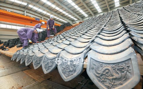 12일 오전 서울 중구 숭례문 복원 현장에서는 기와 잇기 작업이 한창이다. 숭례문은 기와 잇기를 8월 초순에, 단청 공사를 10월 초순에 끝낸 뒤 마무리 작업을 거쳐 12월에 완공할 예정이다. 박영대 기자 sannae@donga.com