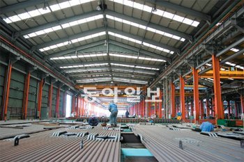 BHI 직원들이 화력발전소 보일러 패널에 들어갈 튜브 위에 올라가 마지막 용접작업을 하고 있다. BHI 제공