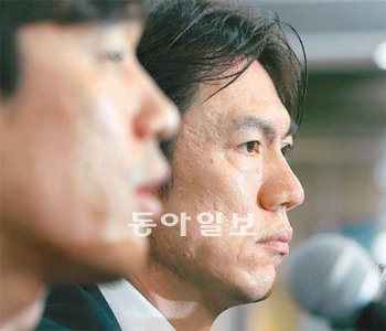 “힘겨운 후배 용기 주려고 나왔습니다” 홍명보 올림픽축구대표팀 감독(오른쪽)이 13일 병역 연기 논란에 대해 입장을 밝히고 있는 박주영 옆에서 굳은 표정으로 앉아 있다. 홍 감독은 박주영이 기자회견을 하는 데 큰 영향을 끼쳤다.양회성 기자 yohan@donga.com