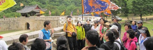 문경새재 제1관문인 주흘관(主屹關)과 연결된 성벽. 안내를 맡은 한정훈 박사(성벽을 등지고 설명하는 사람)는 “길이 곧 ‘새로운 기회’인 것은 예나 지금이나 변함이 없다”고 말했다. 문경=허진석 기자 jameshuh@donga.com