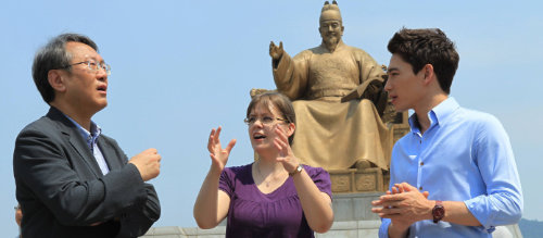 서울 광화문광장 세종대왕 동상 앞에서 송향근 한국어세계화재단 이사장(왼쪽)이 따루 살미넨 씨(가운데)와 아드리안 리 씨(오른쪽)에게 세종대왕의 한글 창제에 얽힌 이야기를 들려주고 있다. 신원건 기자 laputa@donga.com