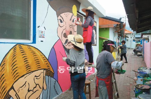 재능 기부에 나선 태백여성수채화협회 ‘물과 나눈 이야기’ 회원들이 19일 태백시 상장동 골목길에서 ‘황 부자 전설’을 주제로 벽화를 그리고 있다. 태백시 제공