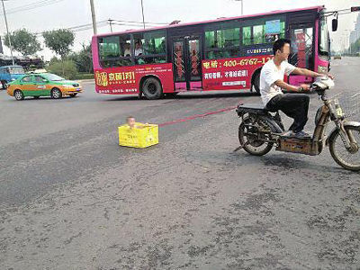 아이를 태운 플라스틱 상자를 오토바이에 매달고 도로를 질주하는 사진이 공개돼 화제다.