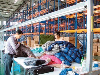 중국 단둥 시 SK 보세물류센터에서 중국 기업 직원들이 북한에서 수입한 옷을 검사하
고 있다. 이 옷들은 다시 유럽으로 수출된다. 단둥=장강명 기자 tesomiom@donga.com