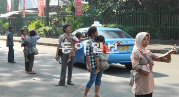21일 오전 인도네시아 자카르타 도심으로 통하는 길목에 승차 정원(3명)을 채우지 못한 차량을 대상으로 ‘머릿수’를 채워주는 아르바이트를 하러 나온 시민들이 길게 늘어서 있다. 자카르타=황진영 기자 buddy@donga.com