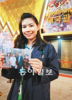 여수엑스포 태국관 진행요원 사로사 랏차웡 씨가 10일 서울 용산 전쟁기념관을 찾은 아버지, 어머니와 함께 찍은 사진을 들고 서 있다. 여수엑스포 태국관 제공
