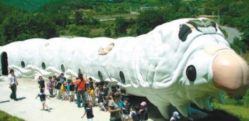 경북 영천시 고경면 오룡리 누에체험학습관에 설치한 대형 누에조형물을 어린이들이 관람하고 있다. 영천시 제공