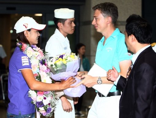 로빈 사임스 코치(오른쪽 두 번째)가 9일 인천국제공항에서 최나연(맨 왼쪽)에게 꽃다발을 건네고 있다. 사진제공｜세마스포츠마케팅