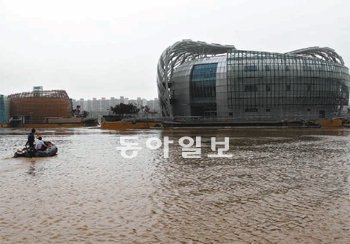 6일 장마로 불어난 한강 물 때문에 서울 서초구 반포동 세빛둥둥섬 통행이 어려워지자
다리를 분리한 뒤 보트를 이용해 관계자들이 이동하고 있다. 김재명 기자 base@donga.com