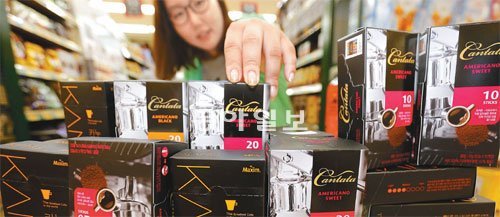 달달한 커피믹스는 싫고, 매번 커피전문점의 원두커피를 사 마시자니 얇은 지갑이 걱정되는 사람들이 늘어나면서 커피업체의 인스턴트 원두커피 마케팅이 뜨겁게 달아오르고 있다. 15일 롯데마트 서울역점에서 소비자 모델이 원두커피 제품을 살펴보고 있다. 원대연기자 yeon72@donga.com