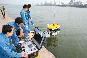 한국로봇융합연구원 직원들이 포항 형산강에서 수중무인잠수로봇 상용화 실험을 하고 있다.
