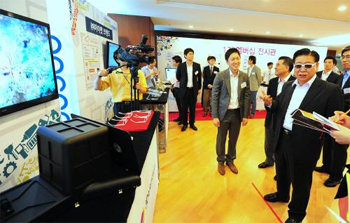 정준양 포스코 회장(오른쪽)이 제3회 아이디어 마켓플레이스에 참가한 업체 ‘3D아이픽처스’의 부스에서 3D 안경을 쓰고 설명을 듣고 있다. 포스코 제공