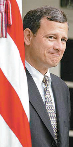 2005년 7월 19일 조지 W 부시 대통령 시절 연방대법원장으로 임명된 존 로버츠 대법원장이 자랑스러운 표정을 짓고 있다. 바로 옆에 성조기가 있다. 사진 출처 CNN