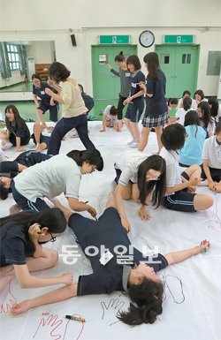 18일 서울 종로구 홍지동 상명대사대부속여고 강당에서 학생들이 예술수업의 일환으로 종이 위에 몸을 활용해 그림을 그리고 있다. 홍진환 기자 jean@donga.com