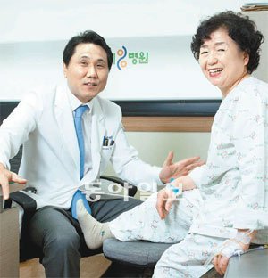 무릎관절 줄기세포 치료를 받은 50대 환자가 주치의인 정용갑 나누리병원 관절센터 소장(왼쪽)과 함께 활짝 웃고 있다. 나누리병원 제공