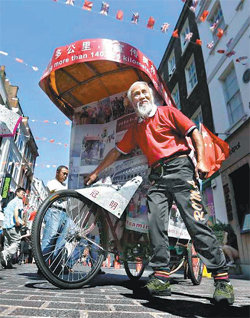 런던 올림픽 개막식에 참석하기 위해 인력거로 중국에서 영국까지 간 중국 농민 천관밍 씨가 자신의 인력거 옆에서 웃으며 포즈를 취하고 있다. 사진 출처 뉴욕데일리뉴스