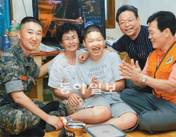 이찬우 대위(왼쪽)가 28일 한국장애인봉사협회 관계자들과 함께 한 지체장애인 가정을 방문해 시간을 보내고 있다. 해병대 제공
