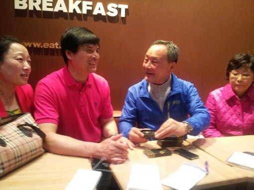 박태환의 아버지 박인호 씨(오른쪽 2번째)가 쑨양의 아버지인 쑨첸홍 씨(왼쪽 2번째)에게 선물을 전하고 있다. 박태환과 쑨양의 부모들은 수영선수 아들을 둔 동병상련을 공유했다. 런던｜전영희 기자