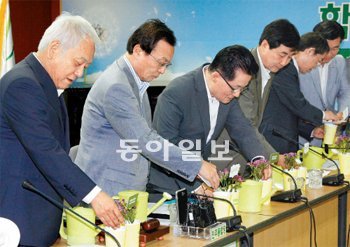 이해찬 대표 등 민주통합당 지도부가 8일 최고위원회의에서 대선 경선 후보 선거인단 모집을 시작하며 패랭이꽃을 만져보고 있다. 민주당은 “패랭이꽃이 영원하고 순결한 사랑이란 꽃말을 가진 데다 민초들이 쓰는 모자를 닮아 패랭이라는 이름이 붙었다”며 선거인단의 상징으로 이 꽃을 선택했다고 설명했다. 안철민 기자 acm08@donga.com