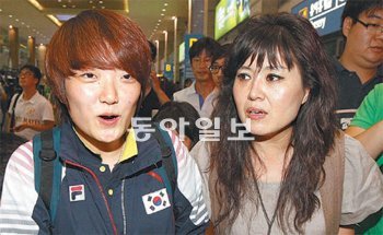 여자 25m 권총 금메달리스트 김장미(왼쪽)가 8일 인천공항으로 마중 나온 어머니 정향진씨와 밝게 웃으며 공항을 빠져 나오고 있다. 신세대다운 발랄한 언행으로 인기를 모으고있는 김장미는 공항에 몰린 수많은 취재진과 환영인파에 막혀 가장 늦게 대표팀 버스에 올랐다. 인천=김재명 기자 base@donga.com