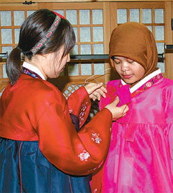 12일 오후 덕성여대 덕우당에서 열린 한국 문화 체험행사에서 덕성여대 학생이 외국 학생의 한복 옷고름을 매주고 있다. 덕성여대 제공