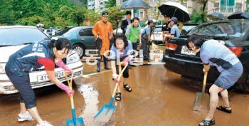 기록적인 폭우로 산사태가 난 전북 군산시 소룡동 한 아파트에서 14일 소방대원과 주민들이 쌓인 토사를 치우고 있다. 전북도 제공