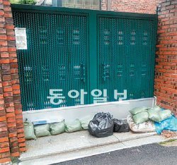 지난해 우면산 산사태를 겪은 서울 서초구 방배동 전원마을 주민들이 15일 비 피해를 대비해 차수판과 모래주머니를 설치해 놓고 있다. 김준일 기자 jikim@donga.com