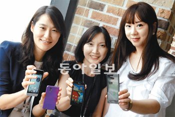 LG전자의 이진희 과장, 김태숙 차장, 홍혜주 대리(왼쪽부터)가 자신들이 마케팅을 맡고 있는 LTE 스마트폰을 들어 보이며 환하게 웃고 있다. LG전자 제공