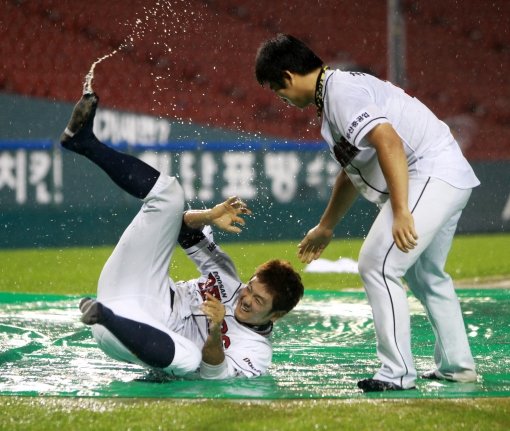 두산 최주환(왼쪽)과 최재훈이 21일 잠실 넥센전이 우천으로 노게임 선언되자 슬라이딩 우천 세리머니를 펼치고 있다. 사진제공｜스포츠코리아
