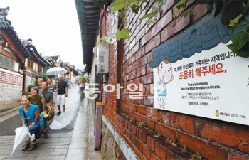 21일 몰려든 관광객으로 몸살을 앓고 있는 서울 종로구 가회동 북촌 한옥마을에 ‘침묵 관광’ 안내판이 설치돼 있다. 김재명 기자 base@donga.com