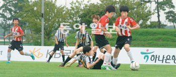 23일 인천국제공항공사청사 운동장에서 열린 전국유소년축구 챔피언십 개막전에서 제주서초교의 고지성(오른쪽)과 성거초교의 류태용(넘어진 선수) 등 양 팀 선수들이 치열하게 공을 다투고 있다. 인천=양종구 기자 yjongk@donga.com