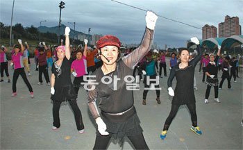 23일 오전 서울 중랑구 면목2동 중랑천 둔치에서 할머니와 아주머니 100여 명이 트로트 음악에 맞춰 신나게 춤추고 있다. 장승윤 기자 tomato99@donga.com