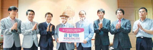 영화배우 고 장진영 씨의 아버지 장길남 씨(왼쪽에서 네번째)가 서거석 전북대 총장(왼쪽에서 다섯 번째)에게 장학금을 전달하고 있다. 전북대 제공