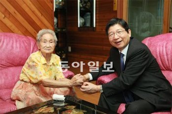 연세대에 기부 의사를 밝힌 김순전 할머니에게 지난달 24일 서울 광진구 중곡동 김 할머니 자택에서 정갑영 연세대 총장이 감사패를 전달하며 두 손을 잡고 있다. 연세대 제공