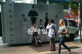 1일 서울 시내에 정차한 여성그룹 카라 홍보용 차량 앞에서 행인들이 기념촬영을 하고 있다. DSP미디어 제공